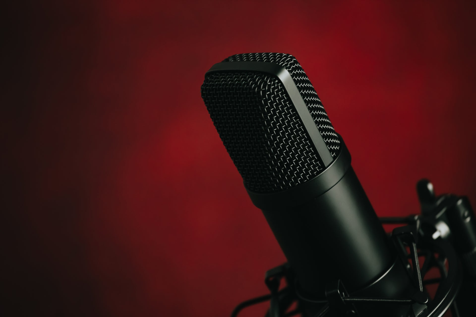 a black mounted metal microphone against red background