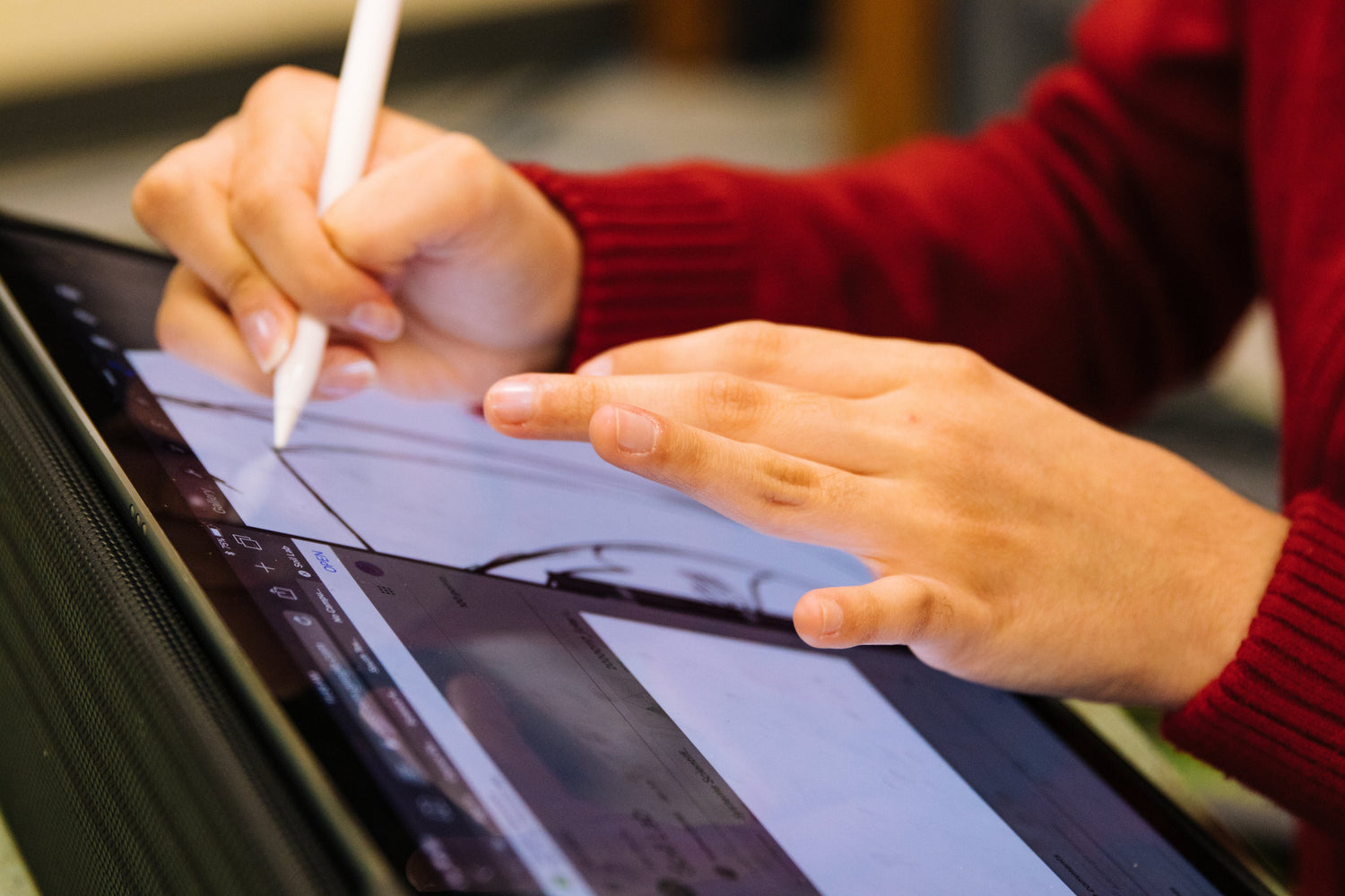 a person using stylus to design on tablet